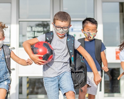 Children at school playing in masks