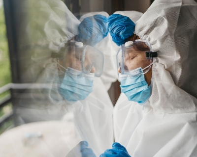 Tired health care working leaning against glass