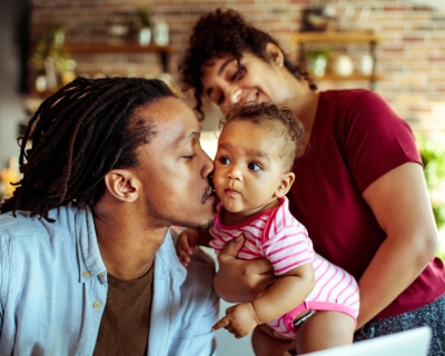 Young black father holding infant kissing her