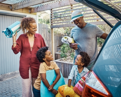 A family packs their car for summer vacation.