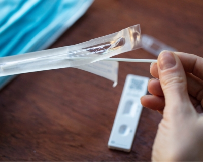 Unwrapping a swab to take a home covid test