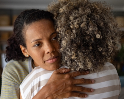 person hugs their friend to console them