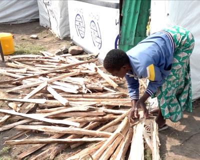 Hellen Anyango sorting a stash of firewood, which she occasionally sells to help support her four children. Nduru camp, Kisimu City, Kenya.