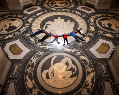 A tour group lays in a row on the decorative Rotunda floor in the Nebraska State Capitol, in Lincoln, Nebraska.