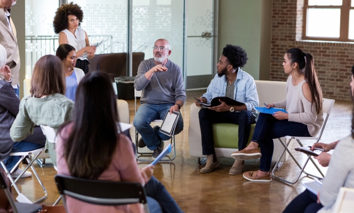 group of adults sitting in a circle talking