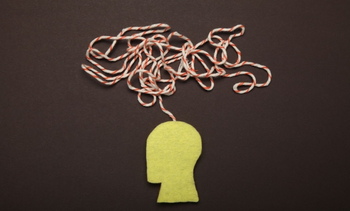 A yellow silhouette of a human head with a jumble of red and white string coming out of the stop