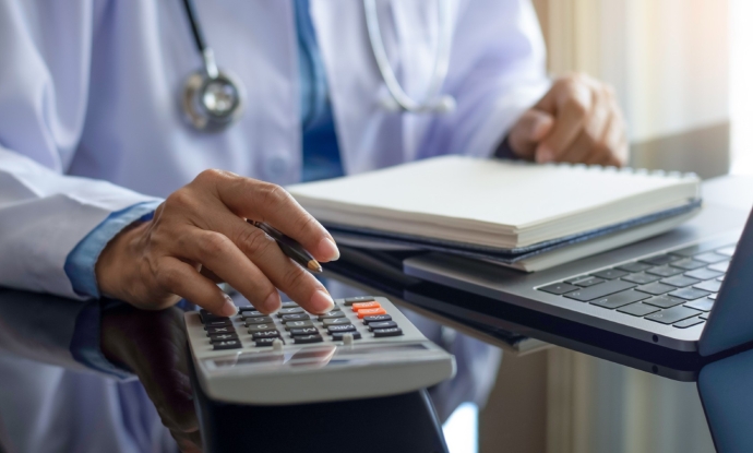 torso showing medical person using a calculator