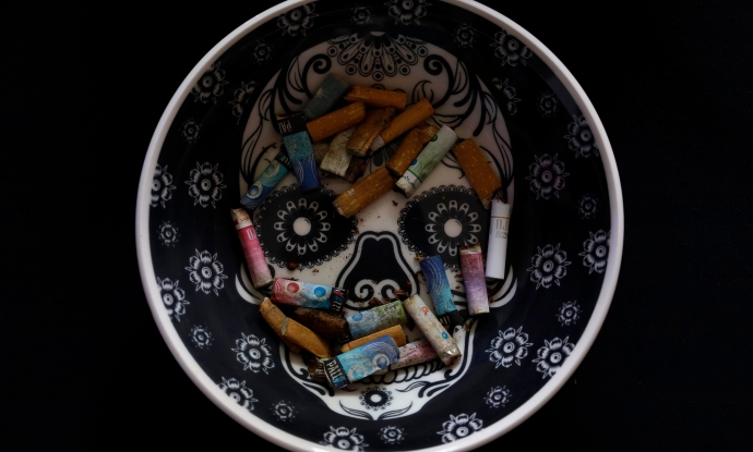 View of cigarette butts on an ashtray with an image of a sugar skull, in Mexico City. 