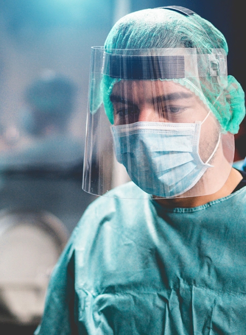 Doctors and nurse preparing to work in hospital for surgical operation during coronavirus pandemic outbreak - Medical workers getting dressed inside clinic - Focus on right man. By DisobeyArt 