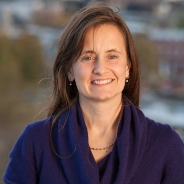 A headshot of a woman wearing a blue sweater